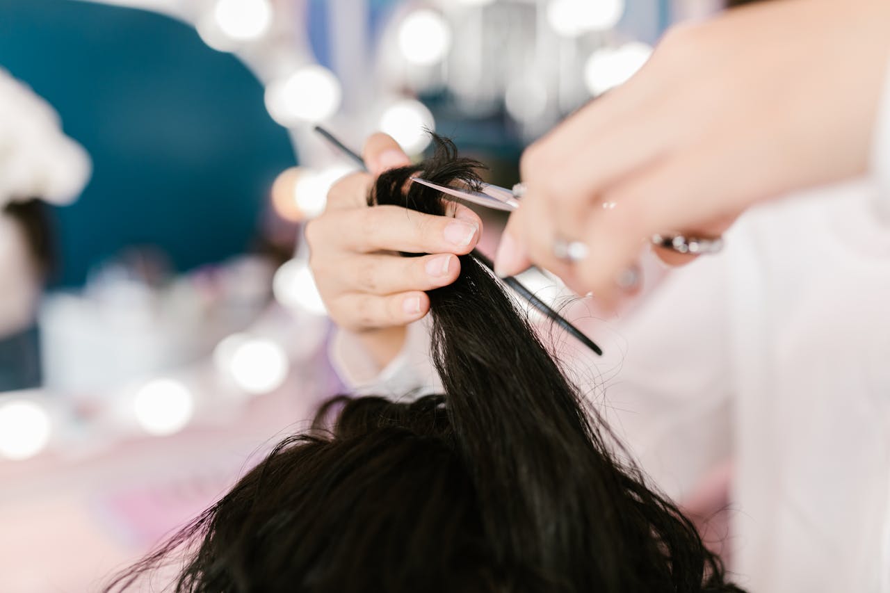 about-01 Close-up of a stylist cutting hair in a contemporary salon setting.