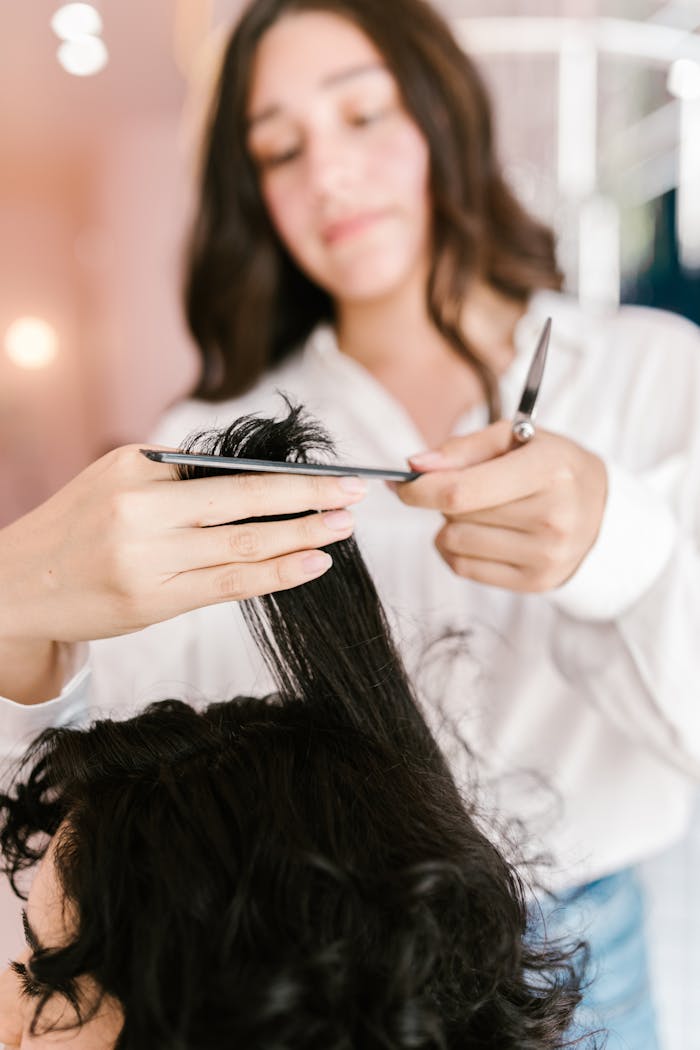 services-01 Close-up of hairstylist expertly cutting client’s hair in a salon setting.